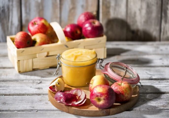 Preserving jar of homemade applesauce and apples