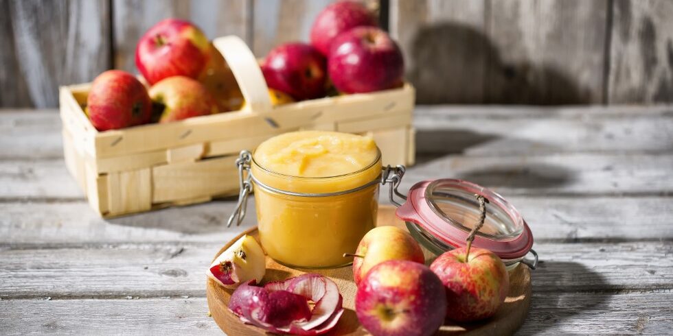 Preserving jar of homemade applesauce and apples